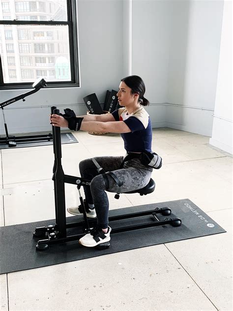 Hinge at your hips, letting your knees come slightly forward as you <strong>squat</strong> down. . Db squat machine